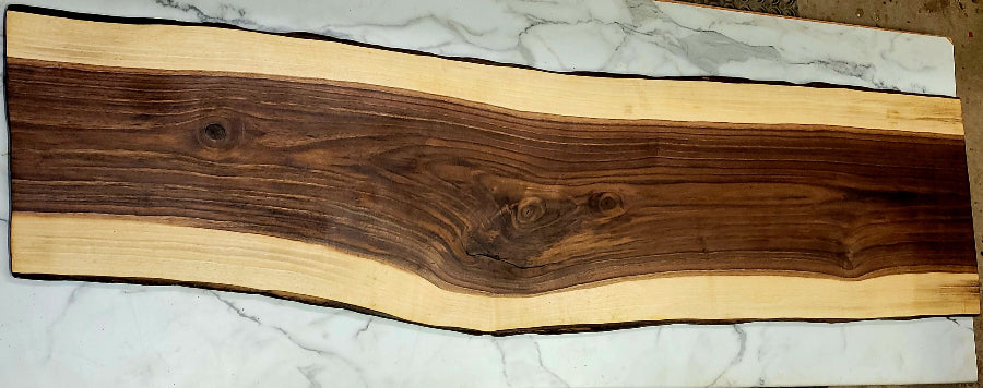 A Live Edge Black Walnut Grazing board with a large interior and light layer around edges with black bark 