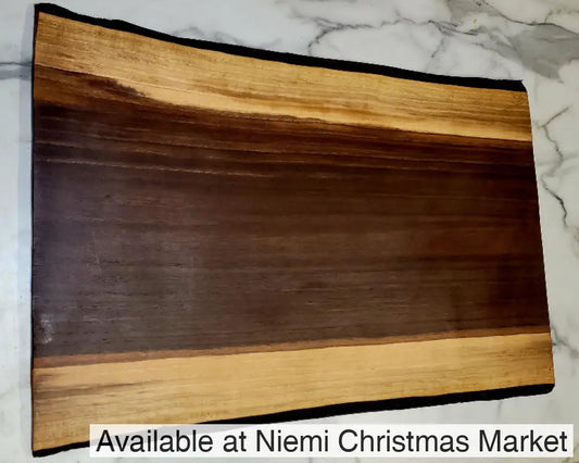 A live edge Black Walnut Grazing board. 
 Medium length, dark centre, with light coloured border, and black bark